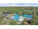 Panoramic aerial view of a community clubhouse, lush landscapes, and sparkling lake at 7507 Ascot Ct, University Park, FL 34201