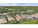 Aerial view showcasing homes in a verdant community near a golf course, nestled among lush trees and landscaping at 7507 Ascot Ct, University Park, FL 34201