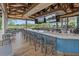 Stylish bar area with wooden accents, multiple TVs, and views of the surrounding lake at 7507 Ascot Ct, University Park, FL 34201