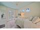 Airy bedroom features light-toned walls, plush bedding, and French doors to a private pool area at 7507 Ascot Ct, University Park, FL 34201