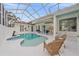 Screened-in pool and patio area with seating, statuary, and lush landscaping at 7507 Ascot Ct, University Park, FL 34201
