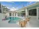 Screened-in pool and patio area with seating and decorative flamingoes and statuary at 7507 Ascot Ct, University Park, FL 34201