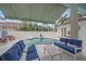 Covered patio and screened pool area with outdoor seating and lush landscaping at 7507 Ascot Ct, University Park, FL 34201