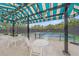 Outdoor seating area overlooks the tennis court with a blue and green surface at 7507 Ascot Ct, University Park, FL 34201