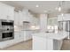 Contemporary kitchen offers stainless steel appliances, white cabinetry, and a large island with seating at 7508 Ripetta St, Sarasota, FL 34240