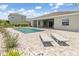 Backyard oasis featuring an in-ground pool, stone patio, and two tanning loungers at 7508 Ripetta St, Sarasota, FL 34240