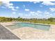 In-ground swimming pool with a sun shelf surrounded by a paver patio and landscaping at 7508 Ripetta St, Sarasota, FL 34240
