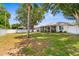 Spacious and grassy backyard with white fence and shade trees at 8638 Bessemer Ave, North Port, FL 34287