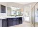 A modern bathroom with a double sink vanity, glass enclosed shower, and natural light at 8640 Stone Harbour Loop, Bradenton, FL 34212