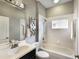 Well-lit bathroom with a single sink vanity, tub-shower combination, and tiled walls at 8640 Stone Harbour Loop, Bradenton, FL 34212