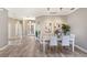 Open-concept dining room with modern decor, wood floors, and views of the foyer at 8640 Stone Harbour Loop, Bradenton, FL 34212