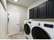 Well-organized laundry room features modern appliances and ample storage space in the black cabinets at 8640 Stone Harbour Loop, Bradenton, FL 34212