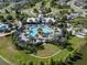 Aerial view of luxurious community pool with palm trees, cabanas, lounge chairs, lake and playground at 8932 Isabella Cir, Parrish, FL 34219