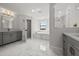 Bright bathroom featuring marble floors, a soaking tub, glass-enclosed shower, and and vanities at 8932 Isabella Cir, Parrish, FL 34219
