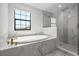Bright bathroom featuring a soaking tub and glass-enclosed shower with marble tile at 8932 Isabella Cir, Parrish, FL 34219