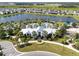 Aerial view of a community center with swimming pool, palm trees, manicured landscaping, and lake at 8932 Isabella Cir, Parrish, FL 34219