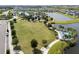Aerial view of a community park with large green, playground, lake and walking paths in a residential neighborhood at 8932 Isabella Cir, Parrish, FL 34219