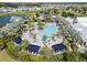 Aerial view of community pool with lounge chairs, palm trees, cabanas and lake at 8932 Isabella Cir, Parrish, FL 34219