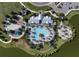 Aerial view of community pool with playground, lounge chairs, palm trees and lake at 8932 Isabella Cir, Parrish, FL 34219