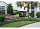Exterior of community sign with lush landscaping and the community center in background at 8932 Isabella Cir, Parrish, FL 34219