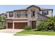 Beautiful two-story home featuring a stone facade, a three-car garage, and tropical landscaping at 8932 Isabella Cir, Parrish, FL 34219
