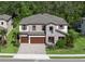Beautiful two-story home featuring a stone facade, a three-car garage, and lush tropical landscaping at 8932 Isabella Cir, Parrish, FL 34219