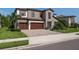 Beautiful two-story home featuring a stone facade, a three-car garage, and tropical landscaping at 8932 Isabella Cir, Parrish, FL 34219