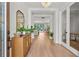 Bright foyer featuring wood flooring, a decorative mirror, and a clear view into the living and dining areas at 8932 Isabella Cir, Parrish, FL 34219