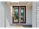 Elegant double front door with glass panels, accented by a 'Welcome Home' mat, inviting guests into a stylish home at 8932 Isabella Cir, Parrish, FL 34219