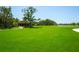 Lush green lawn, perfect for picnics or relaxing, with a covered structure and pond view at 8932 Isabella Cir, Parrish, FL 34219