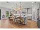 Spacious kitchen with white cabinets, a large island with bar seating, and modern lighting fixtures at 8932 Isabella Cir, Parrish, FL 34219