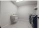 Well-lit laundry room with a utility sink and new, front-loading washer and dryer at 8932 Isabella Cir, Parrish, FL 34219