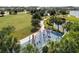 Aerial view of playground with climbing equipment near a lake, walking path and lush green grass at 8932 Isabella Cir, Parrish, FL 34219