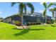 Expansive backyard with a screened-in pool area, beautiful landscaping, and lush green grass at 9229 52Nd E Ave, Palmetto, FL 34221
