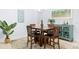 Bright dining area with wooden table and chairs, accented with a tropical painting and décor at 9229 52Nd E Ave, Palmetto, FL 34221