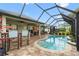 View of the pool and covered patio with an outdoor kitchen, seating, and a screen enclosure at 9229 52Nd E Ave, Palmetto, FL 34221