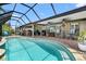 This covered and screened outdoor living space features a sparkling pool, wet bar, and a wall-mounted TV at 9229 52Nd E Ave, Palmetto, FL 34221