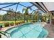 A screened pool area with views of a green space, lush foliage, and a built-in water feature at 9229 52Nd E Ave, Palmetto, FL 34221