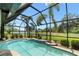 A screened pool area with a view of a lake surrounded by tall palm trees and lush greenery at 9229 52Nd E Ave, Palmetto, FL 34221