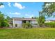 View of the home's exterior and the backyard featuring a lush green lawn and landscaping at 928 Pineland Ave, Venice, FL 34285