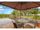 Relaxing outdoor patio with a gazebo, table, chairs, and view of the landscaped backyard at 928 Pineland Ave, Venice, FL 34285