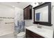 Well-lit bathroom with a vanity, mirror, shower with curtain, and tiled walls at 928 Pineland Ave, Venice, FL 34285