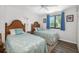 Comfortable bedroom with two twin beds, blue curtains, and a ceiling fan at 928 Pineland Ave, Venice, FL 34285