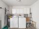 Functional laundry room with washer, dryer, and storage cabinets for convenience at 928 Pineland Ave, Venice, FL 34285