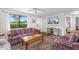 Bright living room featuring wood floors, a ceiling fan, and a large window with backyard views at 928 Pineland Ave, Venice, FL 34285