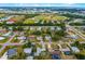 Aerial view of a quiet neighborhood with tree-lined streets, well-maintained homes, and nearby athletic fields at 928 Pineland Ave, Venice, FL 34285