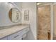 Bathroom featuring vanity with stone countertops, round mirror, and tiled walk-in shower at 9540 High Gate Dr # 1422, Sarasota, FL 34238