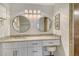 Well-lit bathroom with dual round mirrors, stone countertops, and walk-in shower at 9540 High Gate Dr # 1422, Sarasota, FL 34238