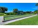 Bocce ball court surrounded by green grass and landscaping with shaded benches for relaxing between matches at 9540 High Gate Dr # 1422, Sarasota, FL 34238