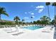 Inviting community pool area with ample seating and palm trees, perfect for relaxation at 9540 High Gate Dr # 1422, Sarasota, FL 34238